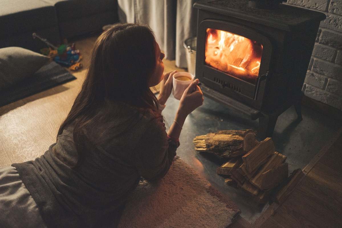 Ragazza si riscalda al fuoco