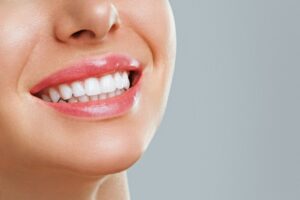 Donna sorride e mostra denti bianchi e sani